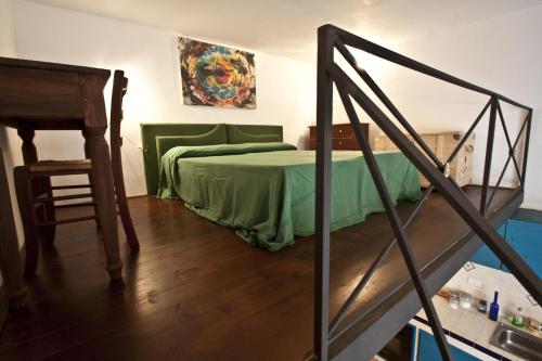 a bedroom with a green bed and a wooden floor at 4Roomsrelax in Catania