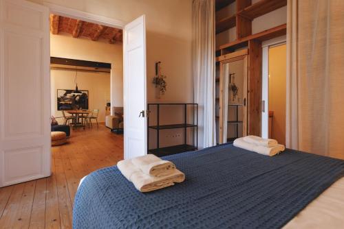 ein Schlafzimmer mit einem blauen Bett und Handtüchern darauf in der Unterkunft Bravissimo Carrer Nou, Cosy 2-bedroom apartment in Girona