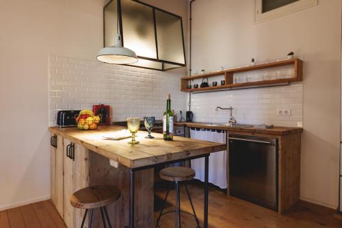 eine Küche mit einer Holzterrasse mit zwei Barhockern in der Unterkunft Bravissimo Carrer Nou, Cosy 2-bedroom apartment in Girona