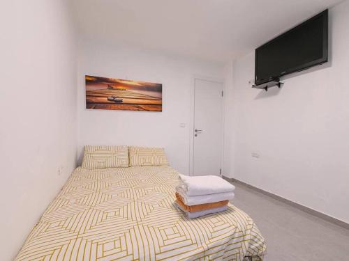 a bedroom with a bed and a flat screen tv at פנטהאוז רפאל - פנטהאוז עם 3 חדרי שינה ומרפסת - יש מקלט בקרבת המקום in Bet Sheʼan
