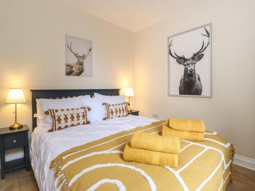 a bedroom with a bed with two deer heads on the wall at Pond Cottage in Alnwick