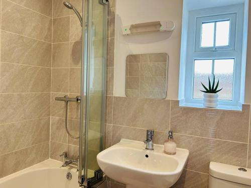 a bathroom with a sink and a shower and a toilet at The Old Stables - a gem surrounded by mountains! in Caernarfon