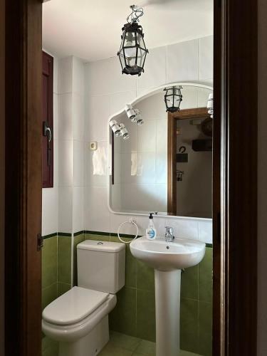 a bathroom with a toilet and a sink and a mirror at Casa la chimenea de Chinchón in Chinchón