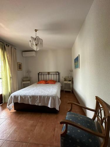 a bedroom with a bed and a chair at Casa la chimenea de Chinchón in Chinchón