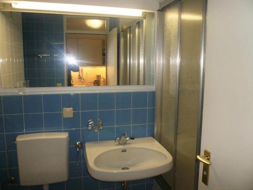 osoba robiąca zdjęcie łazienki z umywalką w obiekcie Haus-am-Meer-App-69 w mieście Westerland
