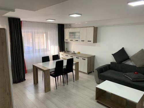 un soggiorno con divano, tavolo e sedie di Cazare bloc nou ultracentral a Râmnicu Vâlcea