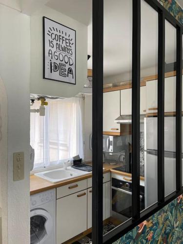 une cuisine avec un évier et une machine à laver dans l'établissement Appartement Cocon, centre St Raphaël, plage à 1min, à Saint-Raphaël