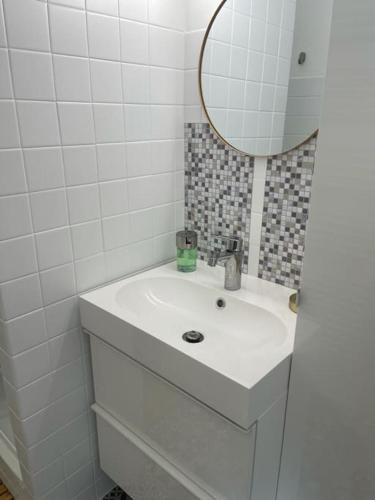 une salle de bain blanche avec un lavabo et un miroir dans l'établissement Appartement Cocon, centre St Raphaël, plage à 1min, à Saint-Raphaël