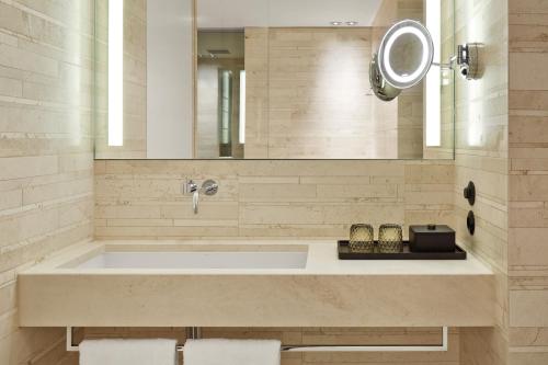 a bathroom with a large tub and a mirror at Roomers Baden-Baden, Autograph Collection in Baden-Baden