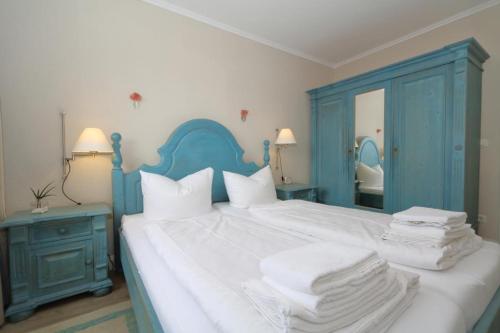 um quarto com uma cama azul e branca com toalhas em Riebschlaeger-Stranduebergang-K-Christiansen em Westerland