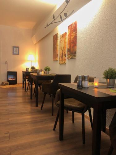 a row of tables in a restaurant with lights on the wall at Berghotel HARZ in Hahnenklee-Bockswiese