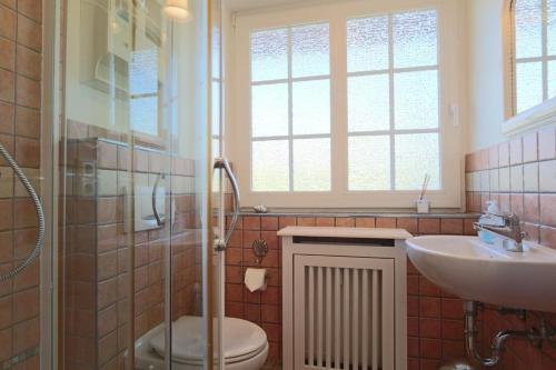 a bathroom with a toilet and a sink and a shower at Sylter-Zuhause-Munkmarsch in Munkmarsch