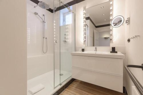 La salle de bains est pourvue d'une douche et d'un lavabo. dans l'établissement Die-Schlosserei-Luxus-in-der-Friedrichstrasse, à Westerland