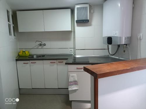 a small kitchen with white cabinets and a sink at VuT Dalia in Avila