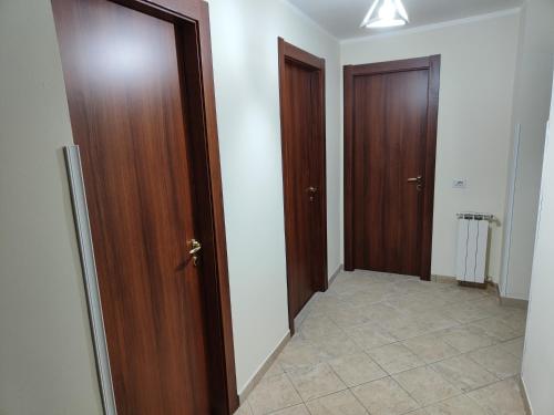 pasillo con 2 puertas de madera y suelo de baldosa en A Casa Di Elena, en Colleferro