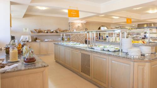 a large restaurant kitchen with a buffet line with dishes at IALYSSOS BAY HOTEL in Ialyssos