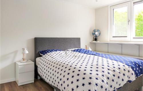 um quarto com uma cama com um edredão azul e branco em Awesome Home In De Heen With Wifi em De Heen