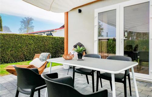 a patio with a white table and chairs at Stunning Home In Heinkenszand With Wifi in Heinkensand
