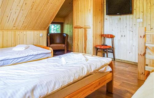 - une chambre avec deux lits et une chaise dans l'établissement Cozy Home In Debki With Kitchen, à Dębki