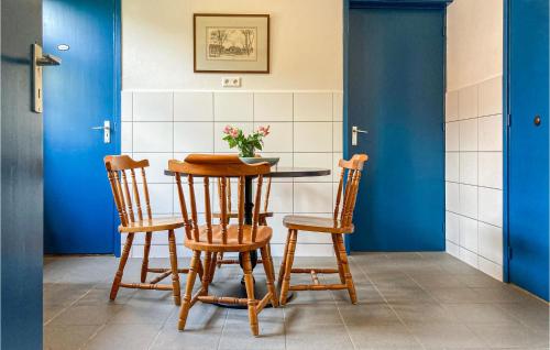 a table with two chairs and a vase of flowers on it at 2 Bedroom Awesome Home In Loon Op Zand in Loon op Zand