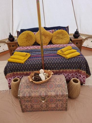 a couple of beds with yellow pillows and a suitcase at Villa Feliza in Güime