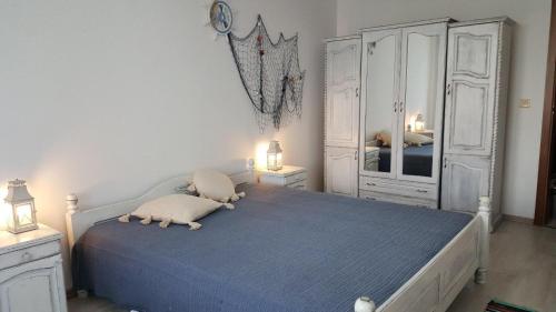 1 dormitorio con 1 cama azul y armarios blancos en Monastery Apartment 14, St. Vlas, en Sveti Vlas