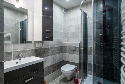 La salle de bains est pourvue de toilettes, d'un lavabo et d'une douche. dans l'établissement TatryTop Lodowy Szczyt, à Zakopane
