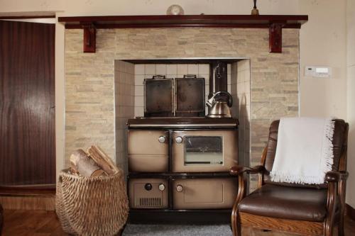 una cocina con una estufa antigua y una silla en 4 Bedroom Traditional Irish Farm House Killybegs, en Donegal