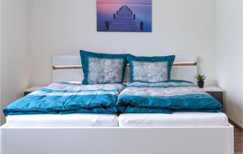 a bed with blue and white comforter and pillows at Beautiful Home In Bleckede With Wifi in Bleckede