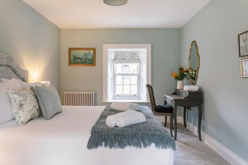 a bedroom with a bed with a desk and a window at The Farmhouse at Corrstown Village in Portrush