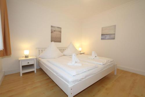 - une chambre avec un lit blanc et 2 lampes dans l'établissement Haus-Sarah-03, à Westerland