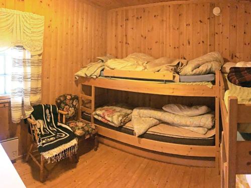 two bunk beds in a room with wooden walls at Holiday home Aurdal in Aurdal