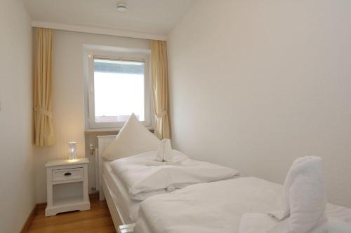 1 dormitorio con 2 camas y ventana en App-Martin-im-Haus-Atlantic, en Westerland