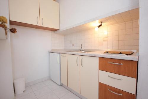 eine kleine Küche mit weißen Schränken und einem Waschbecken in der Unterkunft Apartments by the sea Sali, Dugi otok - 8121 in Sali