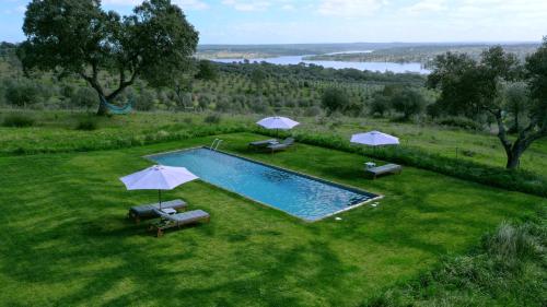 an overhead view of a swimming pool with umbrellas at MONTE DA FIFAS Alentejo, Montargil in Montargil
