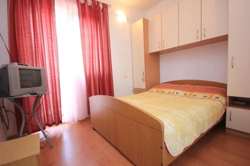 a small bedroom with a bed and a television at Studio Sali 8121b in Sali