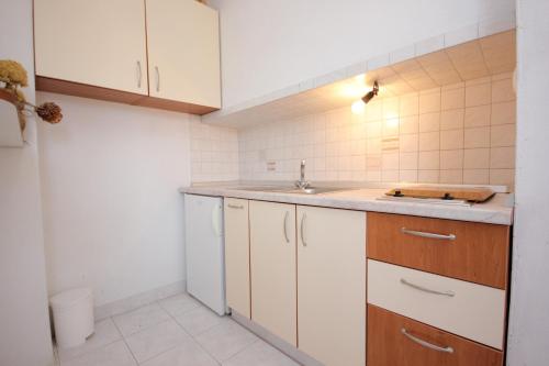 a small kitchen with white cabinets and a sink at Studio Sali 8121b in Sali