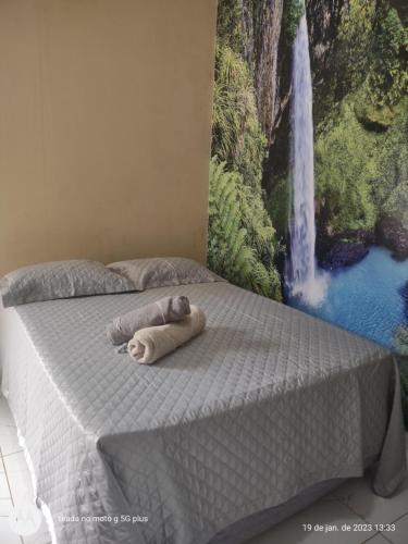 a stuffed animal laying on a bed next to a painting at Casa com Piscina e 3 Quartos Climatizados 8km do Centro in Palmas