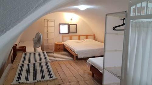 Habitación pequeña con cama y ventana en Lovely traditionnal house with sea view, en Tyros
