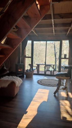 ein Wohnzimmer mit einem Kamin, einem Tisch und Stühlen in der Unterkunft Alpinas de Sollipulli refugio llaima in Melipeuco