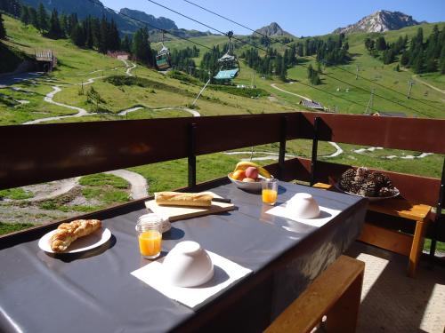 - une table avec de la nourriture et une vue sur la montagne dans l'établissement MON SKI A LA PLAGNE - PLAGNE BELLECOTE Résidence 3000, à Plagne Bellecôte