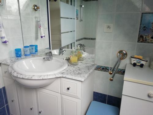 a bathroom with a white sink and a shower at Mon Rêve in Locquémeau