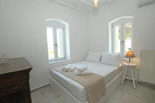 Onverra Villa في Rózia: غرفة نوم بيضاء مع سرير عليه مناشف