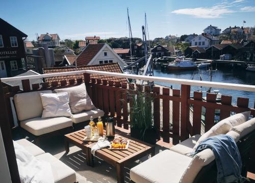 un balcón con sofás y una mesa con bebidas. en Hotell Käringön en Käringön