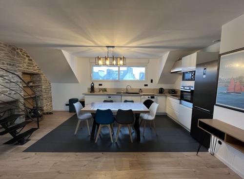 a kitchen with a table and chairs in a room at Les Pierres de Symphorien - parking gratuit in Vannes