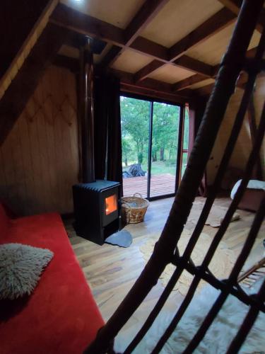 uma sala de estar com um fogão num quarto em Alpinas de Sollipulli refugio llaima em Melipeuco