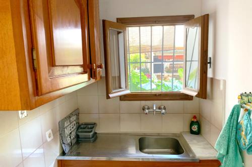 a kitchen with a sink and a window at Spiros Apartments - Agios Gordios Beach, Corfu, Greece in Agios Gordios