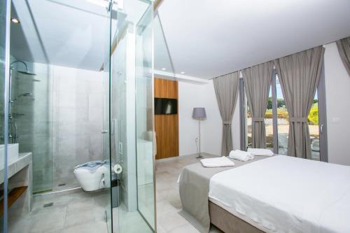 a bathroom with a bed and a glass shower at Happy Days Hotel, Adults Only in Theologos