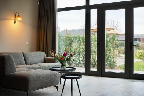 a living room with a couch and a table with flowers on it at Hof van Kleeberg in Mechelen