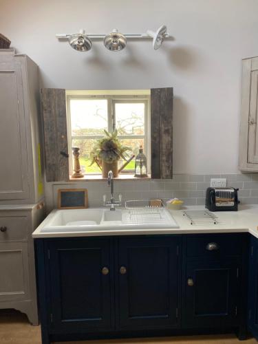 a kitchen with a sink and a window at Holly Cottage The Studio in Hinstock